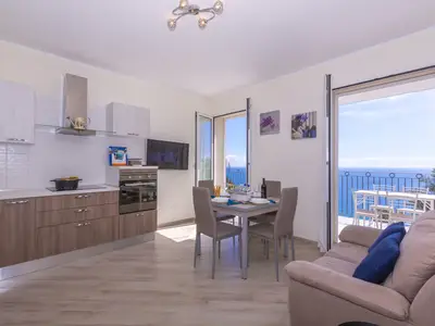 Offenes Wohnzimmer mit Küche, Esstisch und Fernseher