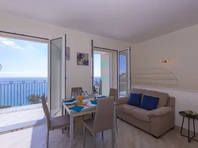 Wohnzimmer mit Esstisch und Außenterrasse