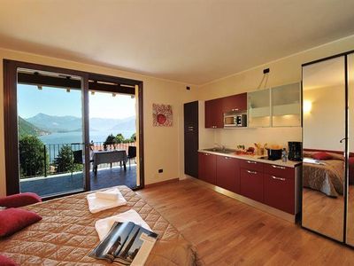 Wohnzimmer mit offener Küche und Zugang zum Balkon