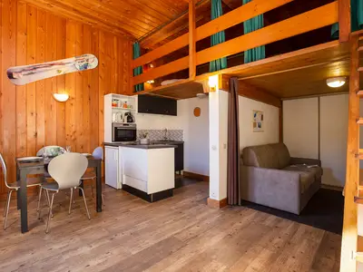 Offener Wohnbereich mit Doppelschlafsofa und Schlafzimmer im Zwischengeschoss