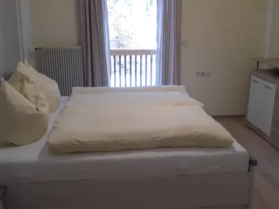 Schlafzimmer mit Doppelbett und Zugang zum Balkon