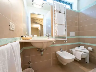 Badezimmer des Zweibettzimmers mit Duschkabine, Waschbecken und Bidet