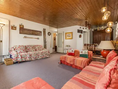 Wohnzimmer mit Doppelsofa und Esszimmer