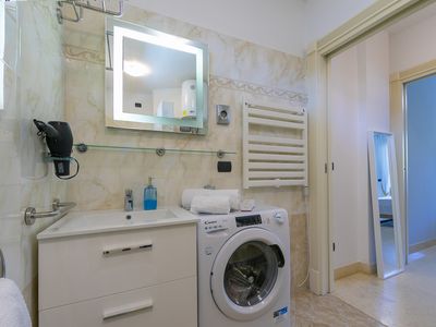 Badezimmer mit Dusche, Waschbecken, Bidet, Toilette und Waschmaschine