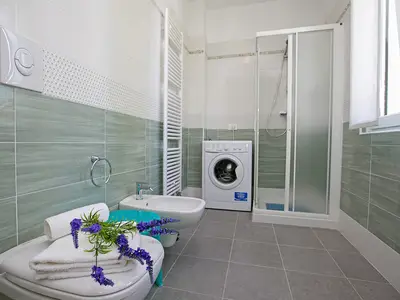 Badezimmer mit Dusche und Waschmaschine