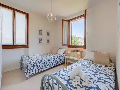 Zimmer mit zwei Einzelbetten, Kleiderschrank und Beistelltisch