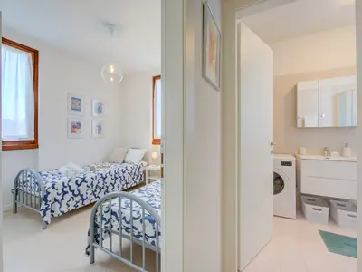 Zimmer mit zwei Einzelbetten, Kleiderschrank und Beistelltisch