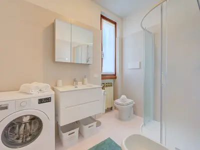 Badezimmer mit Dusche, Waschbecken, Toilette, Bidet und Waschmaschine