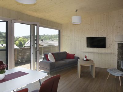 Offen gestalteter Wohn-Essbereich mit Sofa und TV