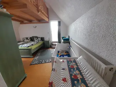Schlafzimmer 1 mit Babybett und Wickeltisch