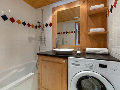 Badezimmer mit Badewanne und Waschmaschine