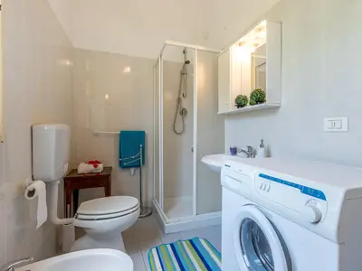 Badezimmer mit Dusche und Waschmaschine