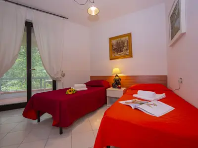 Zweibettzimmer mit Blick auf den Garten und Zugang zur Terrasse