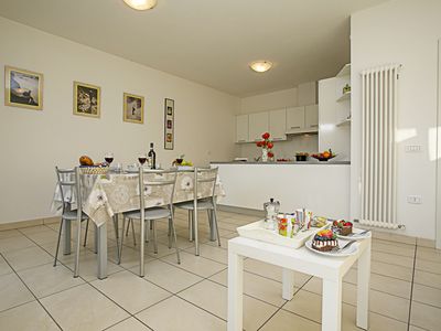 Das Wohnzimmer mit Couchtisch, Esstisch und Blick auf die Küche