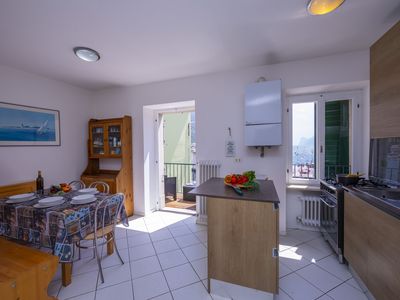 Das helle Wohnzimmer mit Esstisch, Küche und Zugang zum Balkon