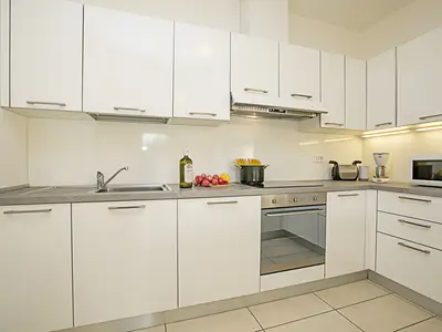 Die voll ausgestattete Küche mit Geschirrspüler, Backofen und Herd