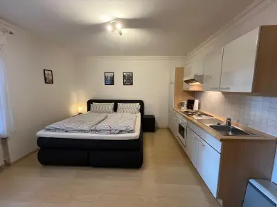 Doppelzimmer mit Boxspringbett und Küchenzeile