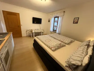 Doppenzimmer mit Boxspringbett, Küche und Esstisch