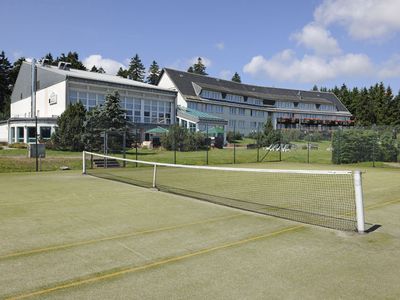 Außenansicht Hotel mit Tennisplatz