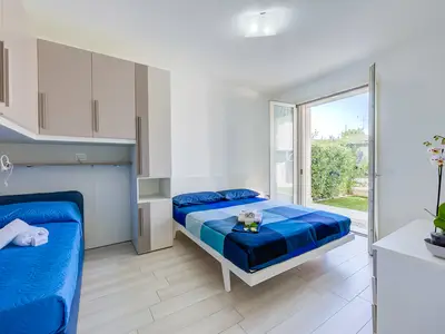 Zweibettzimmer und Einzelbett mit Zugang zur hinteren Terrasse