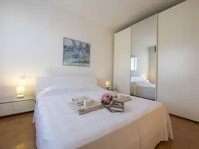 Schlafzimmer mit Doppelbett, Kleiderschrank und TV