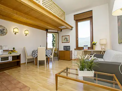 Das Wohnzimmer mit Schlafsofa, Couchtisch und Esstisch vom Eingang genommen