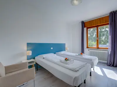 Zimmer mit Betten und Sessel