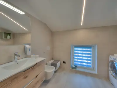 Badezimmer mit Hydromassage-Dusche, Waschbecken, Bidet, Toilette und Waschmaschine