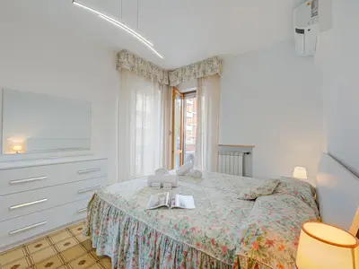 Schlafzimmer mit Doppelbett und Zugang zum Balkon
