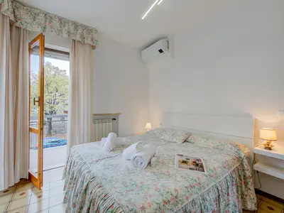 Schlafzimmer mit Doppelbett und Zugang zum Balkon