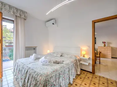 Schlafzimmer mit Doppelbett und Zugang zum Balkon