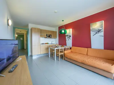Wohnbereich mit Schlafsofa und Blick auf Küche und Korridor