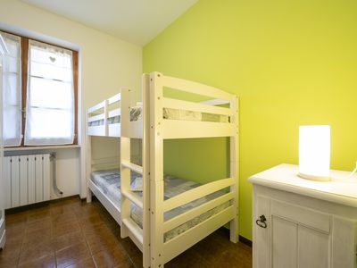 Zimmer mit Etagenbett, Kommode, Kleiderschrank, Nachttischen und Lampen
