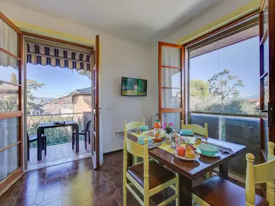 Wohnzimmer mit Esstisch und Zugang zum Balkon