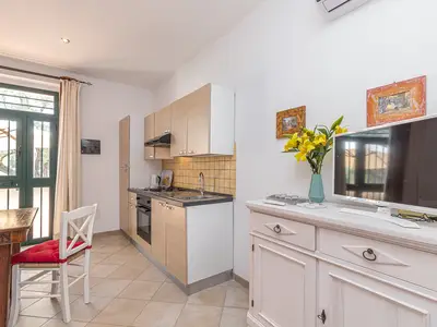 Flat-TV im Wohnzimmer neben der Küche