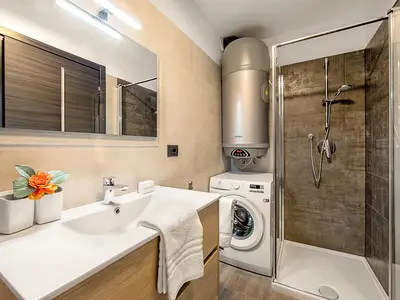 Geräumiges Badezimmer mit Waschmaschine und Dusche