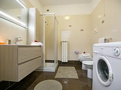 Badezimmer mit Waschmaschine, Bidet, Toilette und Waschbecken