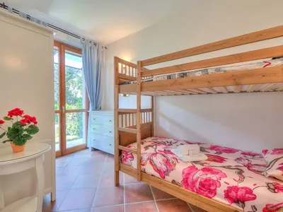 Schlafzimmer mit Etagenbett und Kleiderschrank und Zugang zur Terrasse