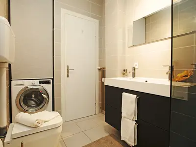 Badezimmer mit Dusche, Toilette und Waschmaschine