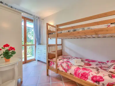 Schlafzimmer mit Etagenbett und Kleiderschrank und Zugang zur Terrasse