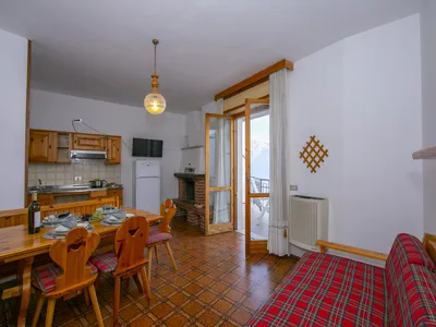 Das Wohnzimmer mit Esstisch, Sessel und Küchentheke