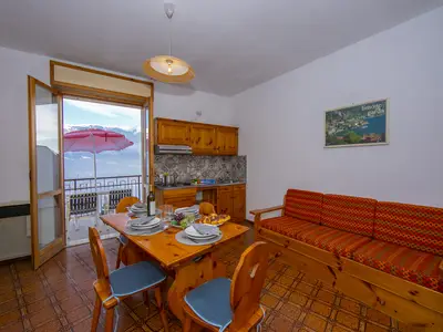 Das Wohnzimmer mit Esstisch und Ausgang zum Balkon