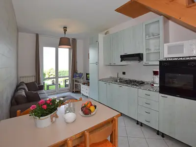 Wohn-Esszimmer mit Kochnische, offen auf die ausgestattete Terrasse