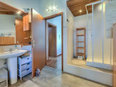 Badezimmer mit Badewanne und Dusche im ersten Stock