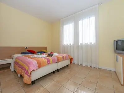 Drittes Schlafzimmer mit Doppelbett und Fernseher im ersten Stock