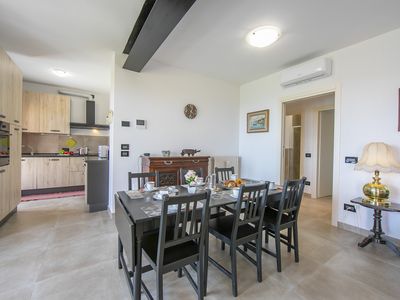 Wohnzimmer mit Esstisch und ausgestatteter Küche