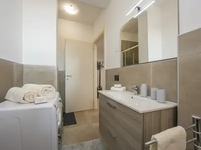 Badezimmer mit Dusche, Waschbecken, Bidet und Waschmaschine