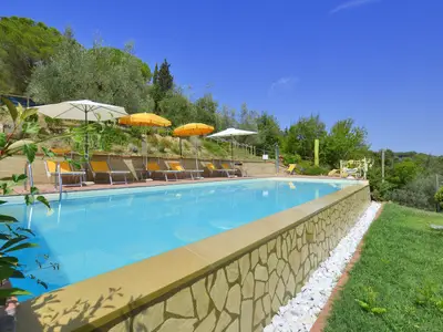 Der Pool ist von einem gepflegten Garten umgeben und bietet einen schönen Blick auf die Landschaft.