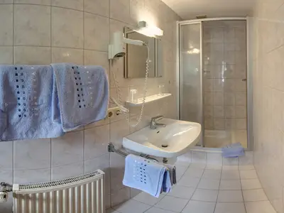 Bad mit Waschbecken und Dusche