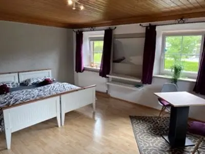 rotes Doppelzimmer mit Sitzecke
